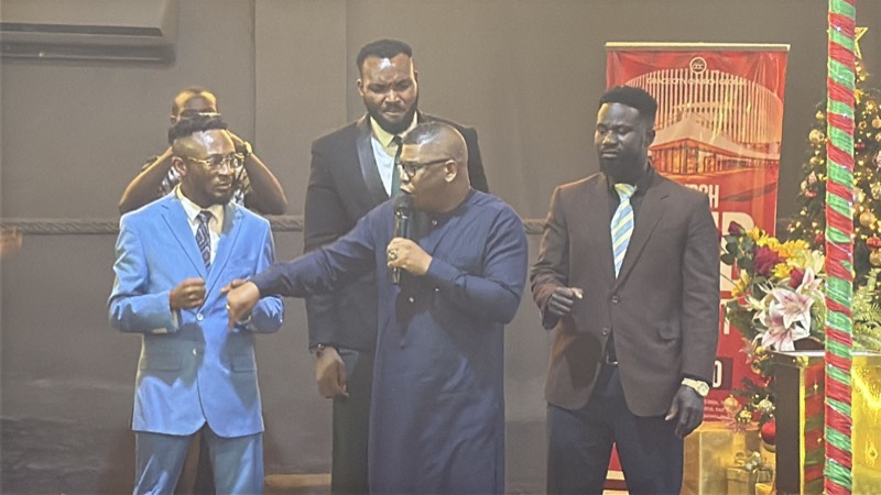 Ministers praying together on a stage