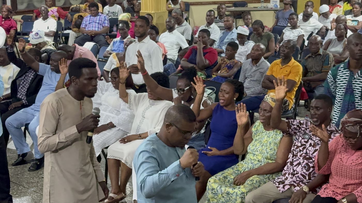 A congregation worshipping with hands raised